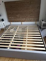 Full view of king size bed frame wooden slats and wood plank headboard, showing the bed construction and base.