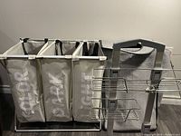 Triple-section laundry hamper with labeled fabric compartments and white metal frame alongside metal shower caddy
