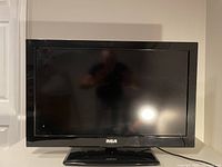 Front view of black RCA 31-inch flat screen TV showing screen and pedestal stand.