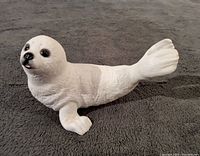 Front-left angled view of the white Arctic pup porcelain sculpture highlighting the detailed face and body texture.