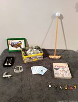 Photo showing assorted golf collectibles including puzzle, golf spoons, pewter ornaments, playing cards, golf ball tee display, and wine glass charms.