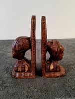 Side view of the two vintage African wood carved book ends, showing the profile of the two busts with detailed hair and garments.