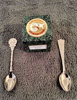 Top view of two Apollo 11 souvenir spoons with green marble Canadair Challenger commemorative block in between