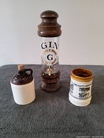 Photo showing the three vintage barware items: the gin dispenser, ceramic jug, and New Orleans stein.