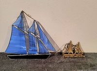 View of both stained glass sailboat wall art and brass sailboat wall hook together showing size and design.