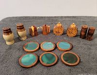 Photo showing all eight vintage salt and pepper shakers arranged in a row behind six handcrafted glass and wood coasters laid out in two rows.