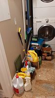 Overview showing cleaning supplies and equipment by laundry machines.