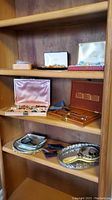 Shelving with boxes containing assorted costume jewelry pieces and small vanity items