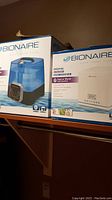 Two boxed Bionaire humidifiers displayed side by side on a shelf.