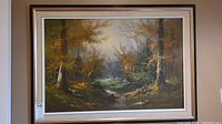 Framed and matted original painting depicting a forest landscape with a stream and autumn foliage, signed by artist W Johnston.