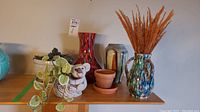 Lot displayed with three decorative vases and plant pots on shelf