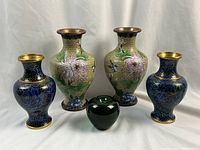Overview of two small blue cloisonne vases and two large yellow-ground cloisonne vases with green glass apple for scale