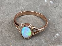 Close-up view of the 9K gold ring with an oval opal gemstone showing the front design and setting.