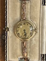 Frontal view of watch seated in original box