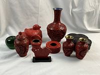 Group shot of all cinnabar lacquer items with a green apple for scale
