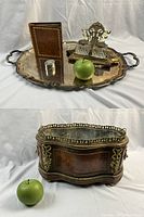 Group shot of silver tray with album, ring box, double inkwell and reference apple on white backdrop, with separate view of wood planter and apple.