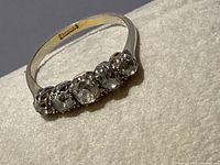 Ring angled on soft surface showing five diamonds across top