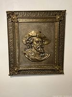 Full view of rectangular brass tableau hung on wall