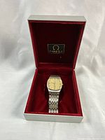 Watch displayed in original Omega box with red velvet interior