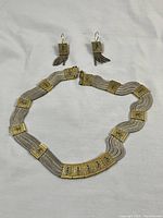 Full set of necklace and earrings displayed on white background, showing rope design and enamel decorated panels