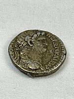 Angled view of obverse showing laureate bust and legend