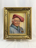 Front view of the oil painting in its ornate gold frame showing the full portrait of the man with the red hat and pipe.