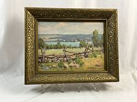 Frontal photo of the framed oil painting showing the composition, colors, and signature.