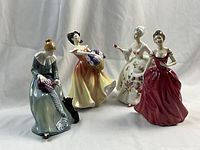 Front view of four Royal Doulton women figurines showing details and colors