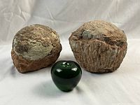 Pair of stones with green glass apple for scale