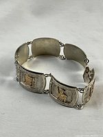 Full view of bracelet laid in a circle on white fabric