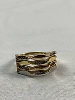 Front view showing wavy layered bands set with 30 stones