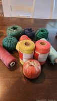 Overview of all yarn and string spools showing various colors including green, black, yellow, pink, and orange.
