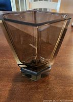 Angled view of the square smoked glass vase on a wooden table showing translucence and thickness of glass.