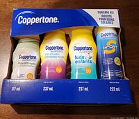 Photo showing the full boxed set of four different Coppertone sunscreen bottles, displaying brand, product names, and SPF values.