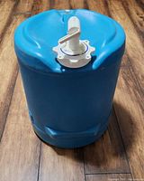 Blue plastic cylindrical water keeper with white tap on top