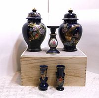 Full set includes two large lidded ginger jars, candle holder, and two small vases on wooden box.