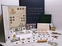 Full view of the coins, coin sets, collector books, and currency included in the lot displayed on a table.