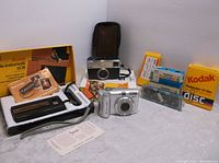 Full lot showing Kodak Instamatic 608, Canon Powershot A630, Kodak Instamatic 133-X, film boxes and Magicubes slide cubes.
