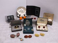 Wide shot showing entire lot including cufflinks, wallets, tie tacks, and money clip arranged on white surface
