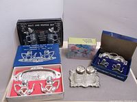 All four mini salt and pepper sets displayed with boxes and trays.