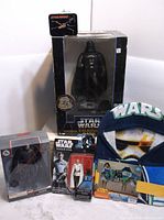 Full lot showing Darth Vader bank in black box, Kylo Ren and Director Krennic action figures, and Star Wars hooded towel.