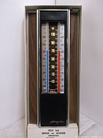 Front view of the vintage Airguide #422 thermometer inside its original box showing temperature scales and indicators.