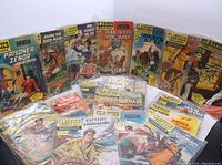 Group photo of 18 vintage Classics Illustrated comic books arranged partially standing and partially laid flat, showing colorful illustrated covers.
