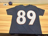 Front view of navy blue Chicago Bears T-shirt with large white number 89 outlined in orange.