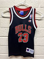 Front view of the black Chicago Bulls basketball jersey with red and white trim, showing number 23 and Bulls logo