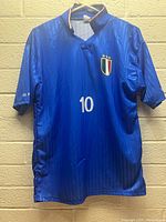 Front view of blue Italy soccer jersey with number 10 and Italian badge with three stars.