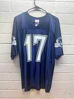 Front view of navy blue Chargers jersey with number 17 on chest and Chargers helmet logos on both sleeves.