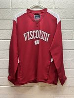 Full frontal photo showing red sweatshirt with white side panels and Wisconsin Badgers logo.