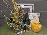 Photo showing overall lot, including framed art, yellow flower arrangement, large yellow vase, artificial boxwood wreath, and small decorative items.