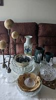Overall view of lot showing crystal candy dish, glass bowls, porcelain vase, marble utensil holders, dried floral stems and napkin rings on table